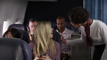 asistente de vuelo que sirve bebidas a los pasajeros del avión video