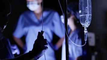 Doctor adjusts IV in operating room video