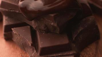 chocolate derretido derramando sobre pedaços de chocolate em câmera super lenta, filmado em phantom flex 4k video