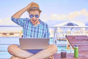 Man is working on vacation with surprised face photo