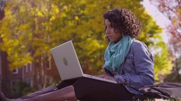 College student on campus in fall using laptop computer video