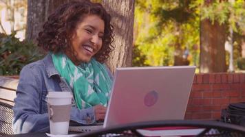 estudante universitário no campus no outono usando um laptop video