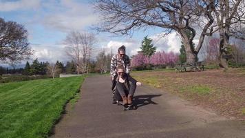 Two young people at park playing on skateboard video