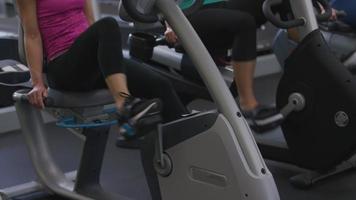 Closeup of woman on exercise bike at gym