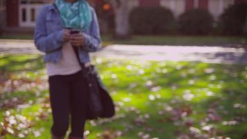 estudiante universitario en el campus en otoño hablando por teléfono celular video