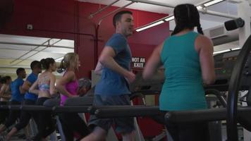 Leute, die im Fitnessstudio auf Laufbändern laufen video