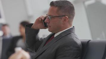 Businessman talking on cell phone at airport