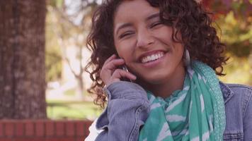 College-Student auf dem Campus im Herbst telefonieren mit dem Handy video