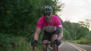 Tracking shot of a male cyclist on country road.  Fully released for commercial use. video