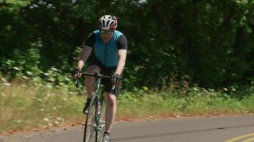 Cyclist pedaling down country road.  Fully released for commercial use. video