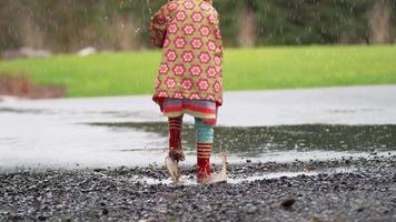 junges Mädchen mit Regenschirm, das im Regen spielt, Zeitlupe, aufgenommen mit Phantomflex 4k video