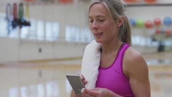 Woman at gym listening to music video