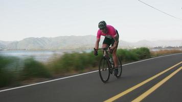 Tracking shot of a male cyclist on country road.  Fully released for commercial use. video