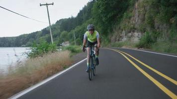 foto de rastreamento de uma ciclista na estrada secundária. totalmente liberado para uso comercial. video