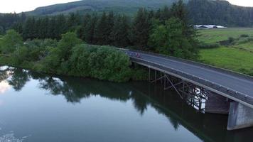 Aerial view of a group of cyclists going over bridge.  Fully released for commercial use. video