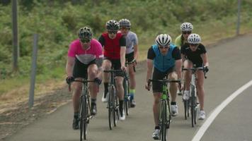 Tracking shot of a group of cyclists on country road.  Fully released for commercial use. video