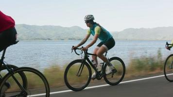 foto de rastreamento de um grupo de ciclistas em uma estrada secundária. totalmente liberado para uso comercial. video