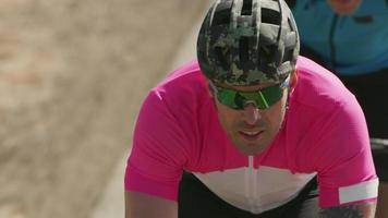 Tracking shot of a group of cyclists on country road.  Fully released for commercial use. video