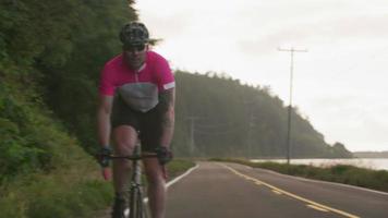 spårningsskott av en manlig cyklist på landsvägen. helt släppt för kommersiellt bruk. video