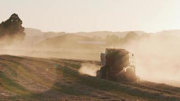 Tracking shot of combine in field at sunset, Willamette Valley Oregon, USA. video