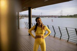 Young woman taking a break during exercise on the river promenade photo