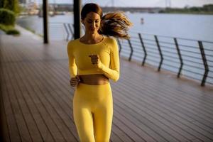 Young woman taking running exercise by the river promenade photo