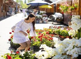 Young woman buying flowers at the flower market photo