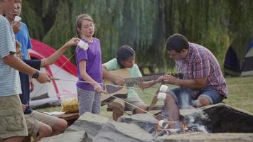 niños en el campamento de verano alrededor de la fogata video