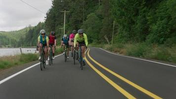 foto de rastreamento de um grupo de ciclistas em uma estrada secundária. totalmente liberado para uso comercial. video