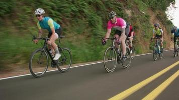 foto de rastreamento de um grupo de ciclistas em uma estrada secundária. totalmente liberado para uso comercial. video