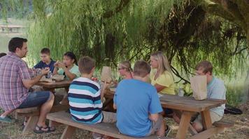 enfants à l'école en plein air en train de déjeuner ensemble video