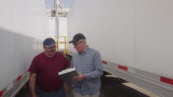 Truck drivers looking over clipboard together.  Fully released for commercial use. video