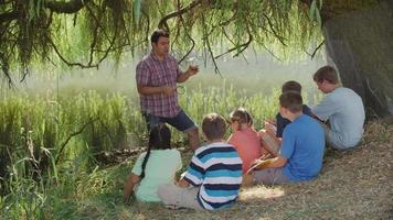 Kids at outdoor school have group lesson by pond video
