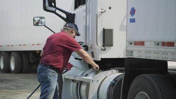 vrachtwagenchauffeur die de brandstoftank van een semi-vrachtwagen vult. volledig vrijgegeven voor commercieel gebruik. video