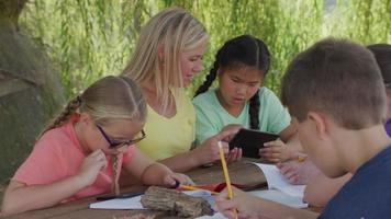 Kids at outdoor school writing in notebooks video
