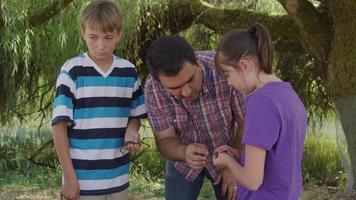 niños en la escuela al aire libre mirando rana video