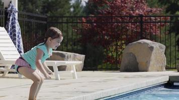 jong meisje springt naar vader in zwembad