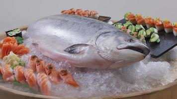 variedad de sushi fresco y salmón entero en hielo.