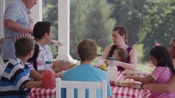 groupe de personnes mangeant et profitant d'un barbecue dans la cour video