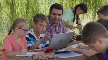 Kids at outdoor school using laptop computer video