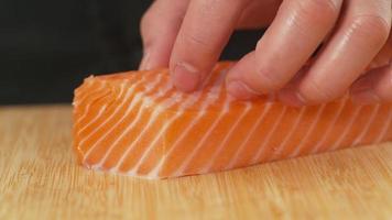 chef de sushi tranchant du poisson saumon video