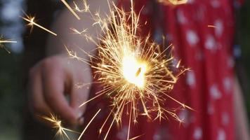 Closeup shot of girl holding sparkler fireworks at 4th of July celebration. video
