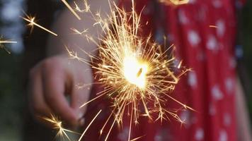 Closeup shot of girl holding sparkler fireworks at 4th of July celebration. video