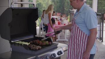 Serving food from grill at backyard barbeque video