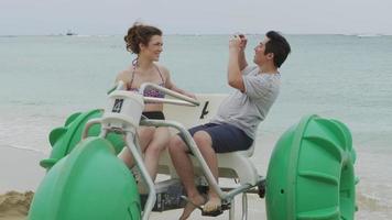 Couple taking cell phone photos on water tricycle in Hawaii video