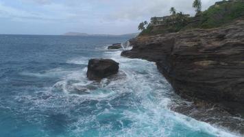 Vue aérienne à faible angle de vagues s'écrasant sur les falaises et les rochers, Oahu, Hawaï video