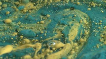 Abstract close up texture of oil with blue green paint, slow motion. video