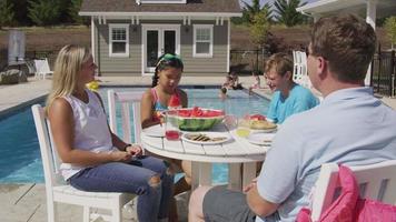 Family having lunch by backyard pool video