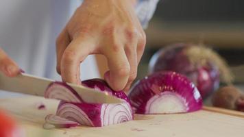 Nahaufnahme eines Mannes, der eine Zwiebel schneidet video