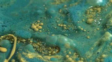 abstracte close-up textuur van olie met blauwe en gele verf, slow-motion. video